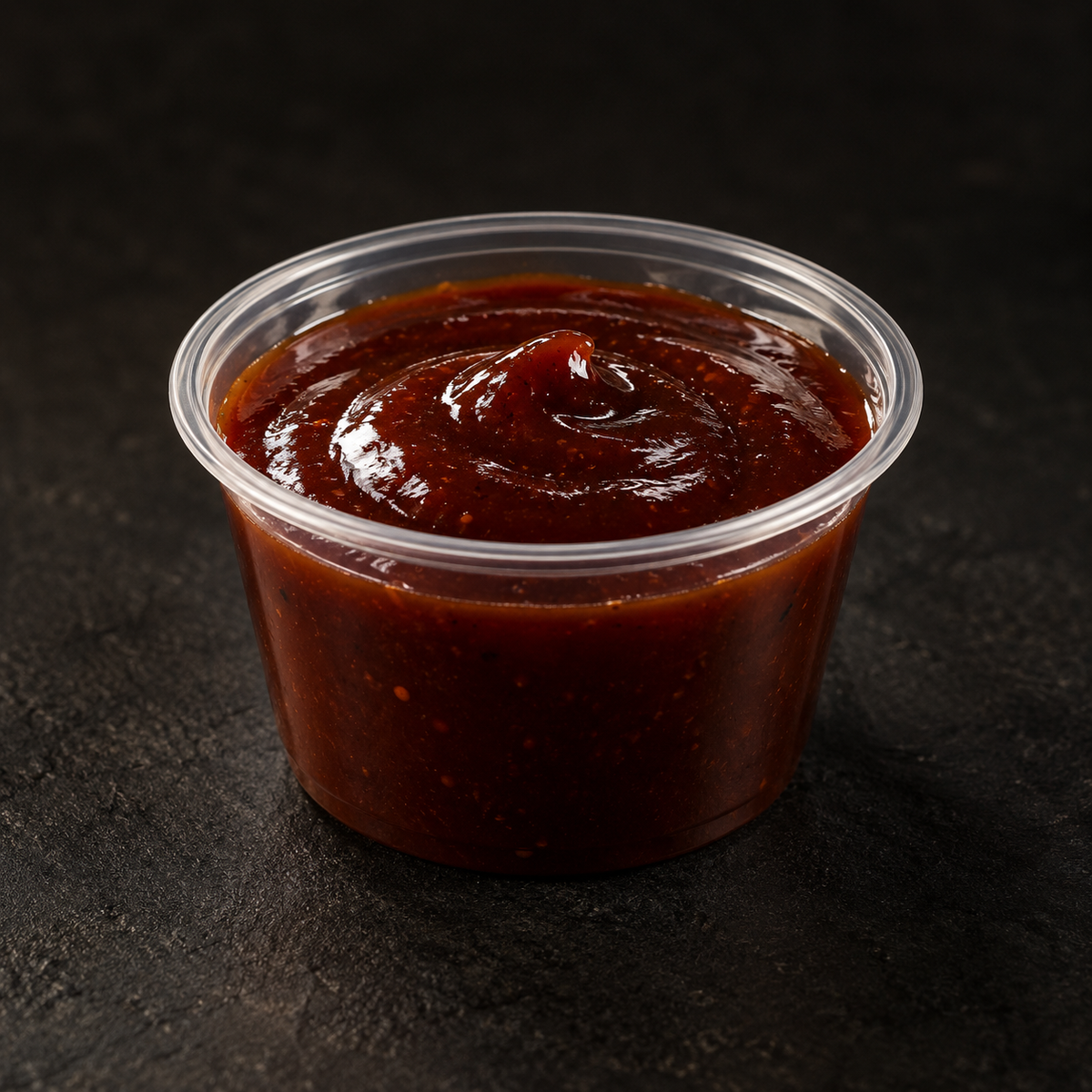 Rich smoky BBQ sauce in a 4 oz pot on a near-black background – Ben’s Fire & Feast
