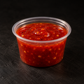 Vivid red chilli sauce in a 4 oz pot on a near-black background – Ben’s Fire & Feast