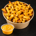Crispy fries with warm cheddar cheese sauce on a near-black background – Ben’s Fire & Feast