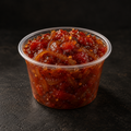 Spicy tomato and caramelised onion chutney in a 4 oz pot on a near-black background – Ben’s Fire & Feast